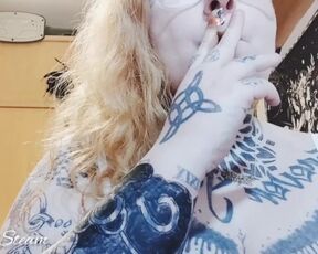 Tattooed girl smokes a cigarette